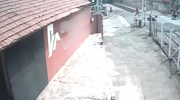 Motociclista escapa por pouco de ser atropelada por trem após tombar e cair em cima dos trilhos; vídeo